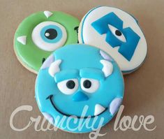 three decorated cookies with monster faces on them