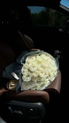 a bouquet of white roses in the back seat of a car