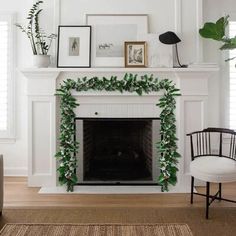 a living room with a white fireplace and green garland on it's mantel