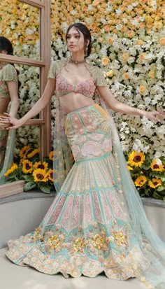 Luxuriously crafted this pastel hued tulle lehenga set is truly one of a kind. The mermaid skirt is embellished with golden foil hearts, sequin patches and flared silhouettes while the structured blouse is embellished with gorgeous pink patches and is further extended with net elongated cape, this luxurious ensemble make you stand out in the crowd.  Seen on #AlannaPanday.  Available at BIBI London. To book your appointment, call us at 07931 999111. Alanna Pandey, Alanna Panday, Manish Malhotra Lehenga, Haldi Dress, Mumbai Wedding, Haldi Outfits, Haldi Outfit, Gaun Fashion, Dresses Traditional