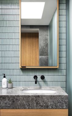 a bathroom sink with a mirror above it and a soap dispenser on the counter