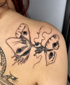 a woman with a tattoo on her back has a dragon and butterfly design on it