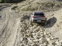 an suv is parked on the side of a rocky road