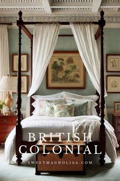 a canopy bed with white drapes and pillows in a blue bedroom decorated for the british colonial era