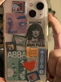 a person holding up a cell phone case with stickers on it and various pictures