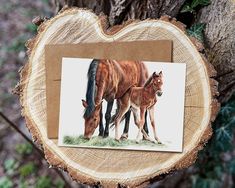 two horses are standing next to each other on a piece of wood that has been cut in half