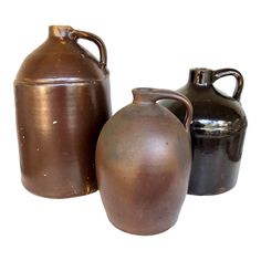 three brown and black vases sitting next to each other