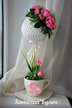 a white vase with pink flowers in it