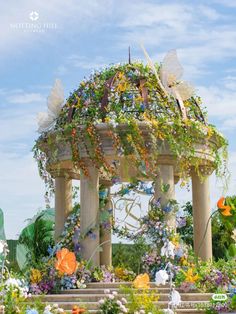 a gazebo covered in lots of flowers and butterflies