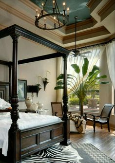 a bedroom with a canopy bed and zebra rug