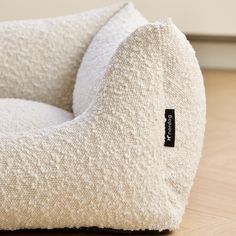 a close up of a bean bag chair on a wooden floor with a name tag