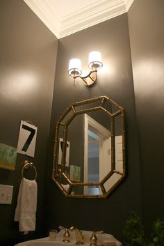 a bathroom with a sink, mirror and lights on the wall in it's corner