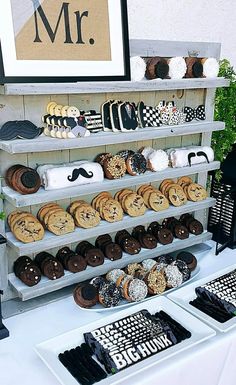 a table topped with lots of cookies and pastries next to a sign that says mr