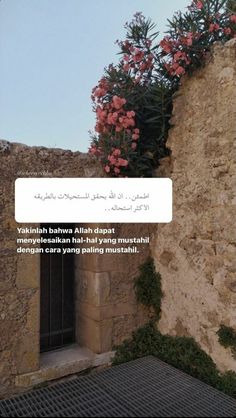 an old building with flowers growing out of it's window sill and the words written in arabic