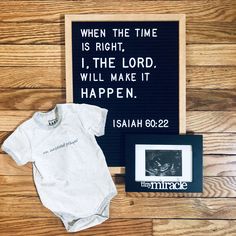 a baby's first birthday gift set up on a wooden floor next to a framed photo