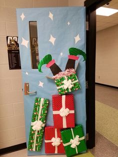 a door decorated to look like presents with santa's hat and scarf on top