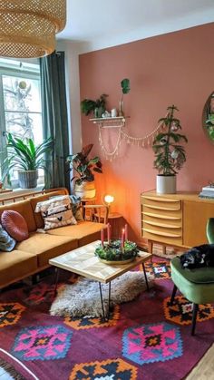 a living room filled with furniture and a cat laying on top of a rug in front of a window