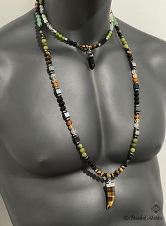 A 2-strand necklace . The longer necklace is made with 8 mm beads, the shorter - with 6 mm beads. Clasp: 1 lobster claw clasp that holds both strands. The longer necklace is with a Tiger Eye horn-shape pendant, the shorter necklace is with a smaller black Agate pendant. Longer necklace beads: tiger eye, obsidian, hematite,green Canada jade, clear crystal quartz, citrine, carnelian, black onyx, green aventurine. Shorter necklace beads: tiger eye, hematite, black onyx, green Canada jade, clear crystal quartz, citrine. Longer necklace length: 35 inch Shorter necklace length: 18 inch Beaded Necklaces For Men, Men Beaded Necklace, Unique Mens Necklace, Mens Beaded Necklaces, Mens Jewelry Necklace, Healing Crystal Jewelry, Black Jewelry, Men's Necklace, Beaded Jewelry Patterns