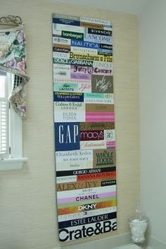 a bathroom with a toilet, sink and window covered in decorative wall hangings on the wall