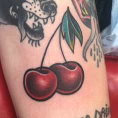 a tattoo with two cherries on it