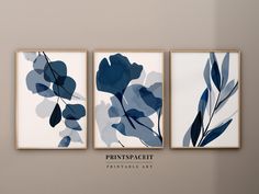 three framed art pieces with blue flowers and leaves on them in a neutral colored room