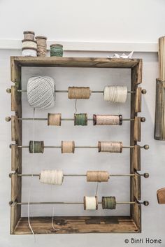 a wooden frame with spools of thread and yarn on it