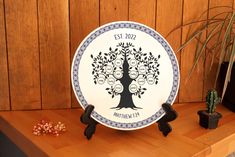 a plate with a family tree on it sitting on a table next to a potted plant