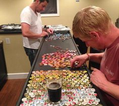 two men are looking at buttons on a table