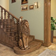 a statue of a lion sitting on top of a wooden stair case next to a set of stairs