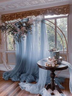 a table with a cake on top of it next to a blue drape curtain