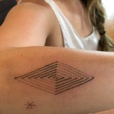 a woman with a tattoo on her arm that has an image of a diamond in it