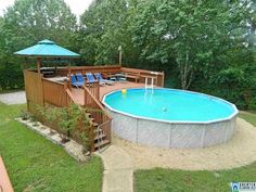 an above ground swimming pool with deck and umbrella