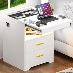 a laptop computer sitting on top of a white desk next to a drawer with a keyboard and mouse