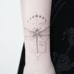 a woman's arm with a dragonfly tattoo on it