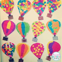 colorful hot air balloons are hanging on the wall in front of a bulletin board that says,