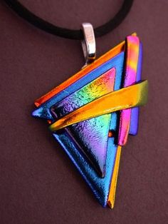 a multicolored triangle shaped pendant on a black cord