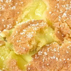 a close up of a cake with powdered sugar on top and green fruit in the middle