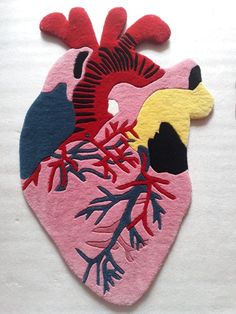 a felt heart with two birds on it