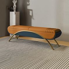 an orange and blue bench sitting on top of a rug