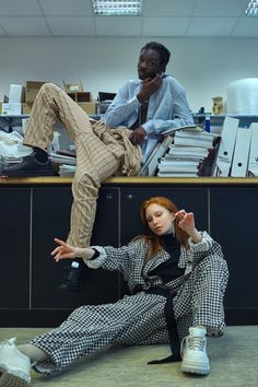 two people sitting on the floor in an office