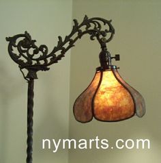 a lamp hanging from the side of a wall next to a light fixture with an ornate design on it