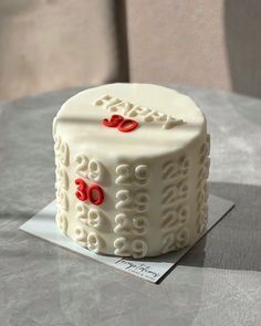 a white cake sitting on top of a table covered in frosting and red decorations