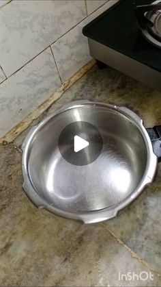 a frying pan sitting on the ground in front of a stove top burner