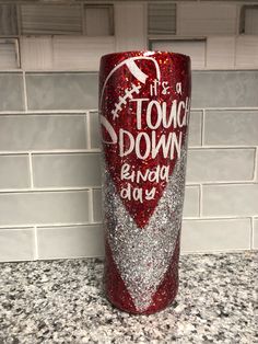 a red and silver glitter tumbler with the words touch down every day on it