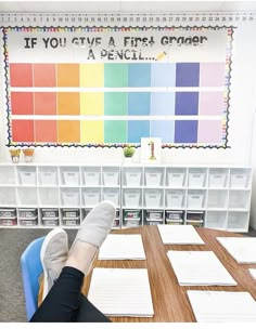 a person sitting at a table with their feet up in front of a colorful wall