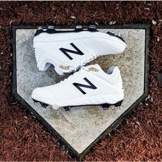 a pair of new balance shoes sitting on top of a stone slab