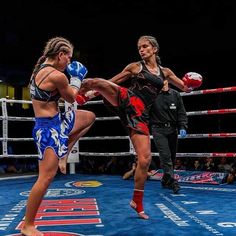 two women kick punches at each other in a boxing ring