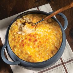 a large pot filled with food on top of a white napkin next to a wooden spoon