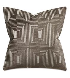 a brown and white pillow with square shapes on the front, along with a black background