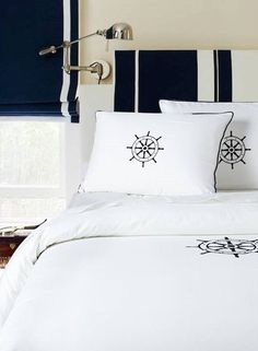 a bed with white sheets and black pillows